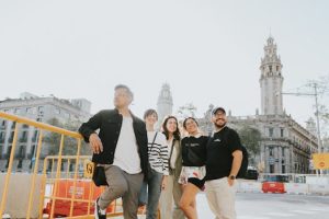Group of friends enjoying a sunny day in Barcelona near a historic building.